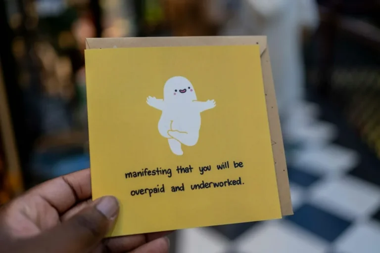 Hand holding yellow card with ghost and 'overpaid, underworked' text